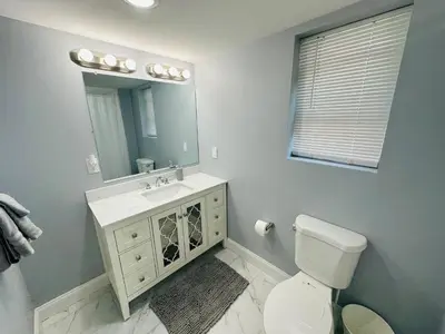 a bathroom with a toilet and a sink and a mirror at 15% OFF | EWR| NYC | Metropolis Serenity Haven in Newark