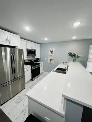 a kitchen with a stainless steel refrigerator and white cabinets at 15% OFF | EWR| NYC | Metropolis Serenity Haven in Newark