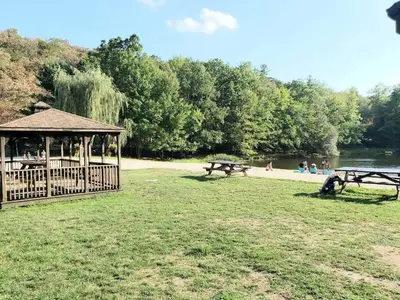 a group of picnic tables and a gazebo in a park at Modern 4 Bedroom Home with Sauna and Game Room in Gated Lake Community in East Stroudsburg