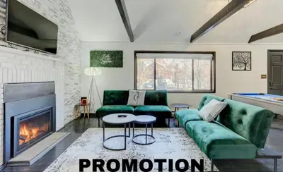 a living room with a green couch and a fireplace at Modern 4 Bedroom Home with Sauna and Game Room in Gated Lake Community in East Stroudsburg