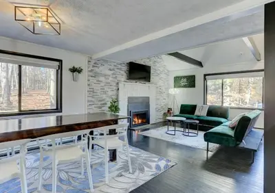 a living room with a dining table and a fireplace at Modern 4 Bedroom Home with Sauna and Game Room in Gated Lake Community in East Stroudsburg