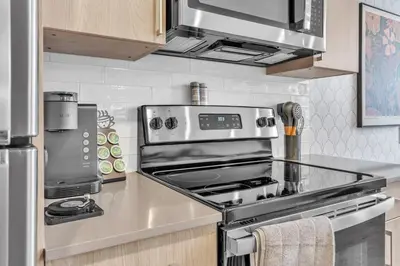 a kitchen with a stainless steel stove top oven at Floor To Ceiling Windows- Bridge Views - Studio in Philadelphia