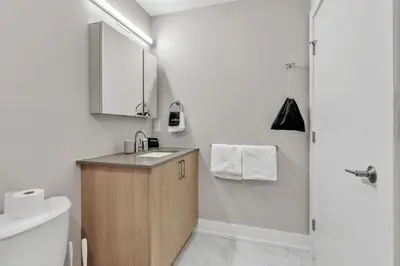 a white bathroom with a sink and a shower at Floor To Ceiling Windows- Bridge Views - Studio in Philadelphia