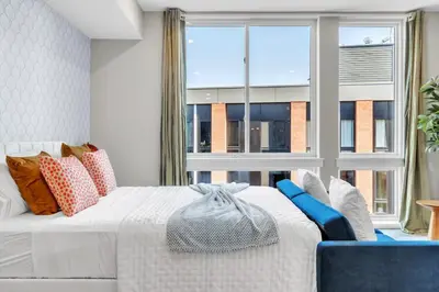 a bedroom with a white bed and a large window at Floor To Ceiling Windows- Bridge Views - Studio in Philadelphia