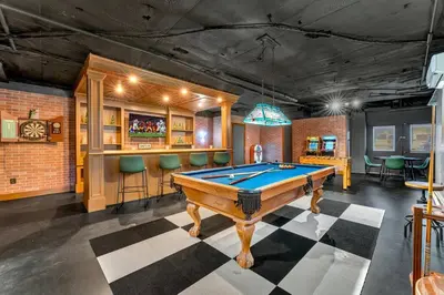 a pool table in a room with a bar at 5BR Lux Cabin w HotTub Sauna Pool FirePit GameRoom in East Stroudsburg
