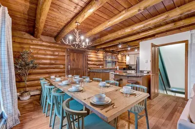 a dining room with a large wooden table and chairs at 5BR Lux Cabin w HotTub Sauna Pool FirePit GameRoom in East Stroudsburg
