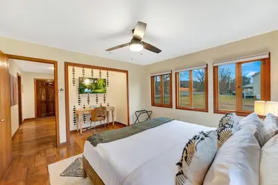 a bedroom with a large bed with a ceiling fan at 5BR Lux Cabin w HotTub Sauna Pool FirePit GameRoom in East Stroudsburg