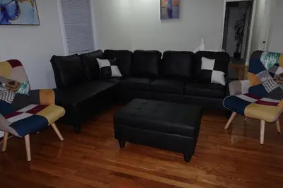 a living room with a black couch and chairs at HouseDF in Bayonne
