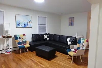 a living room with a black couch and chairs at HouseDF in Bayonne