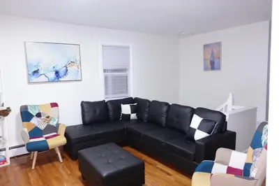 a living room with a black couch and chairs at HouseDF in Bayonne