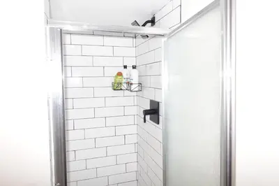 a bathroom with a shower with white subway tiles at HouseDF in Bayonne