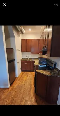 a kitchen with wooden cabinets and a wooden floor at The LOFT in Rahway