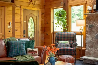 a living room with two chairs and a table at Rustic Ridge Log Cabin: Hot Tub, Games, Views! in Mount Pocono