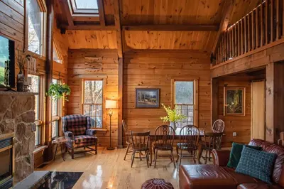a living room with a table and chairs at Rustic Ridge Log Cabin: Hot Tub, Games, Views! in Mount Pocono