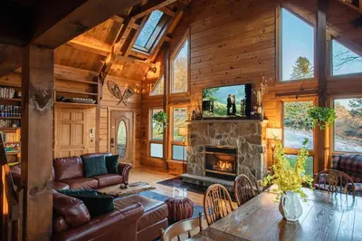 a living room with a fireplace in a log cabin at Rustic Ridge Log Cabin: Hot Tub, Games, Views! in Mount Pocono