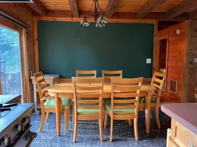 a dining room with a wooden table and chairs at Rustic Ridge Log Cabin: Hot Tub, Games, Views! in Mount Pocono