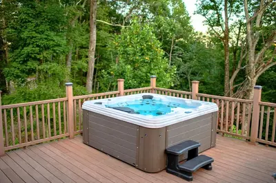 a hot tub sitting on a wooden deck at Rustic Ridge Log Cabin: Hot Tub, Games, Views! in Mount Pocono