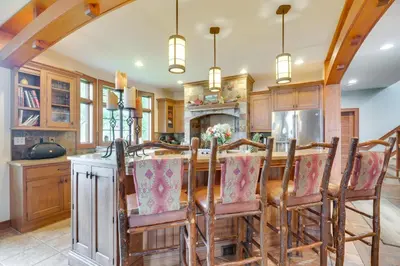 a kitchen with a wooden table and chairs at Luxe Family Home on Orange Lake with Private Dock! in Newburgh