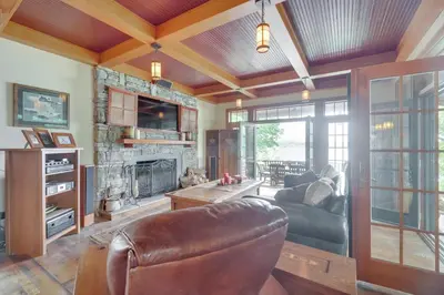 a living room with a leather couch and a fireplace at Luxe Family Home on Orange Lake with Private Dock! in Newburgh