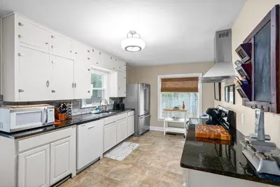 a kitchen with white cabinets and black counter tops at 3BD 102 Madison Ter in Springfield