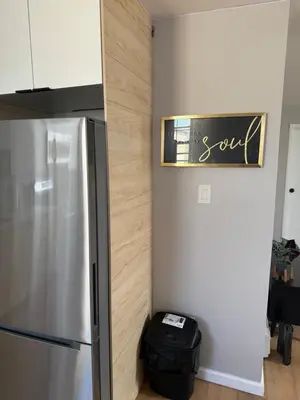 a kitchen with a refrigerator and a sign on the wall at 15 mins to NYC-Great Apartment Great for Family in West New York