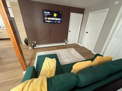 a living room with a green couch and a tv at 15 mins to NYC-Great Apartment Great for Family in West New York