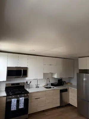 a kitchen with white cabinets and a stove top oven at 15 mins to NYC-Great Apartment Great for Family in West New York