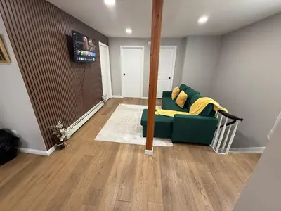 a living room with a green couch with a yellow blanket at 15 mins to NYC-Great Apartment Great for Family in West New York