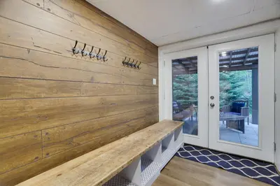 a wood paneled wall in a home with a bench at Emerald Escape Lake, Theater, Game Room & More! in Long Pond