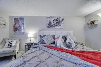 a bedroom with a large bed and a chair at The Cozy Peak 5 Minutes to Ski in Tannersville