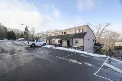 a parking lot with a white car parked in front of a building at The Cozy Peak 5 Minutes to Ski in Tannersville