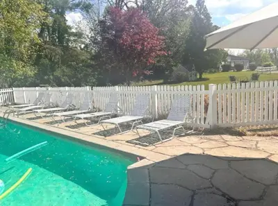 a row of lounge chairs next to a white fence at The Villa Farm