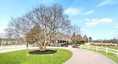 a tree in a park next to a white fence at The Villa Farm