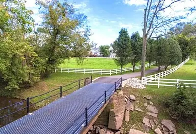 a wooden walkway in a field with a fence at The Villa Farm