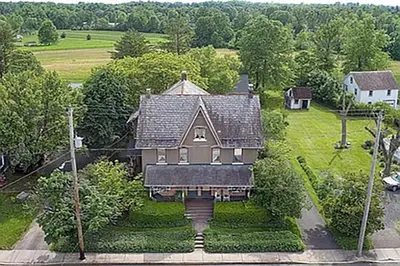 an aerial view of a large house with trees at Historic Main Street Getaway