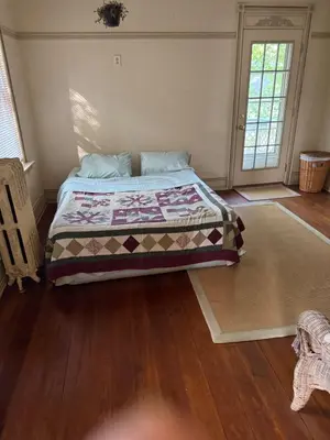 a bedroom with a bed with a quilt on it at Historic Main Street Getaway