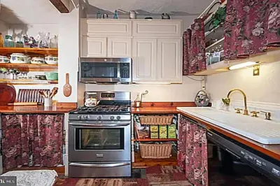 a kitchen with a stove and a sink at Historic Main Street Getaway