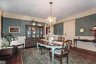 a dining room with a table and chairs and a chandelier at Historic Main Street Getaway
