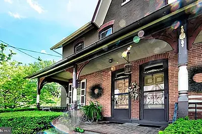 a brick house with a front door with a fountain at Historic Main Street Getaway