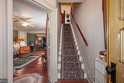 a staircase in a home with a living room at Historic Main Street Getaway