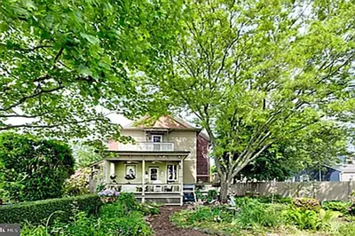 an old house with a fence in a yard at Historic Main Street Getaway