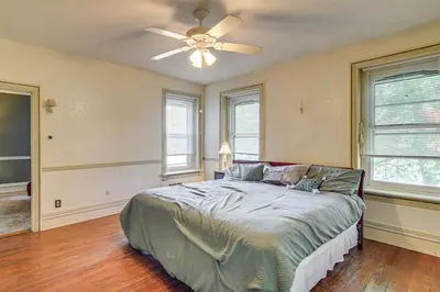 a bedroom with a bed and a ceiling fan at Historic Main Street Getaway