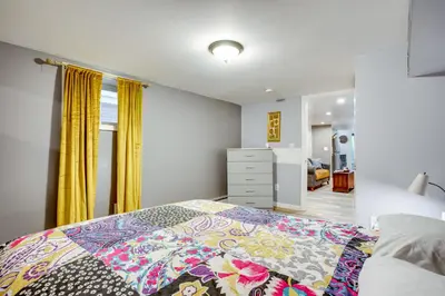 a bedroom with a bed with a colorful quilt on it at Apt 2 Mi to Prudential Center and Dtwn Newark! in Newark