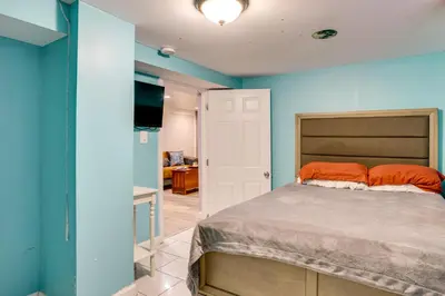 a bedroom with blue walls and a bed with orange pillows at Apt 2 Mi to Prudential Center and Dtwn Newark! in Newark