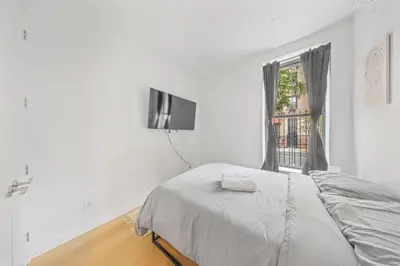 a white bedroom with a bed and a window at Private room by Times Square Manhattan in New York