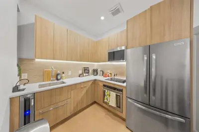 a kitchen with a stainless steel refrigerator and wooden cabinets at Private room by Times Square Manhattan in New York