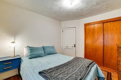 a bedroom with a bed and a wooden cabinet at Home 7 Mi to Binghamton University! in Vestal