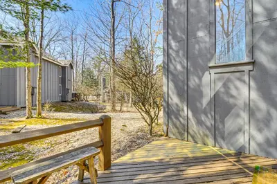 a wooden bench sitting next to a building at Steps to Jack Frost Ski Resort Townhome with Decks in White Haven