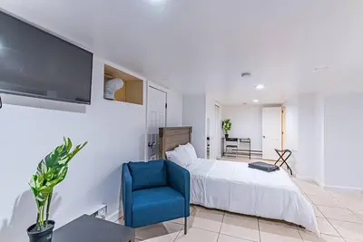 a bedroom with a bed and a blue chair at Newark NJ Private Suite NYC Path Train in Newark