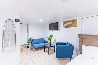 a bedroom with a bed and two chairs and a tv at Newark NJ Private Suite NYC Path Train in Newark